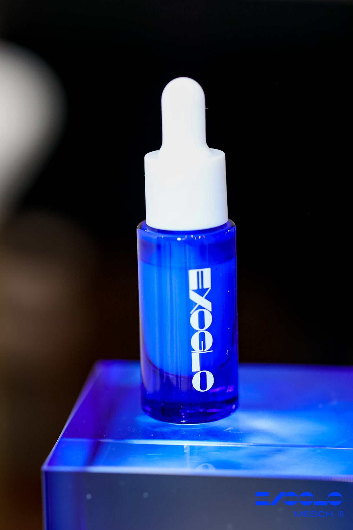 EXOGLO Serum 10ml bottle on a glowing blue glass block