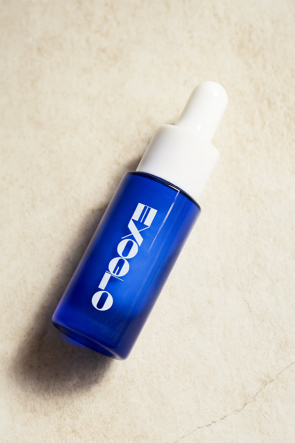 EXOGLO Serum 10ml travel bottle lying on linen