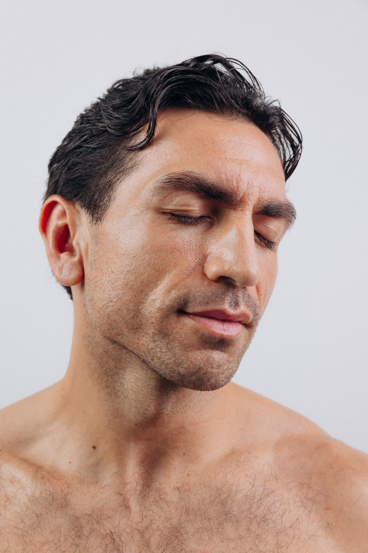 A man with his eyes closed against a pale background