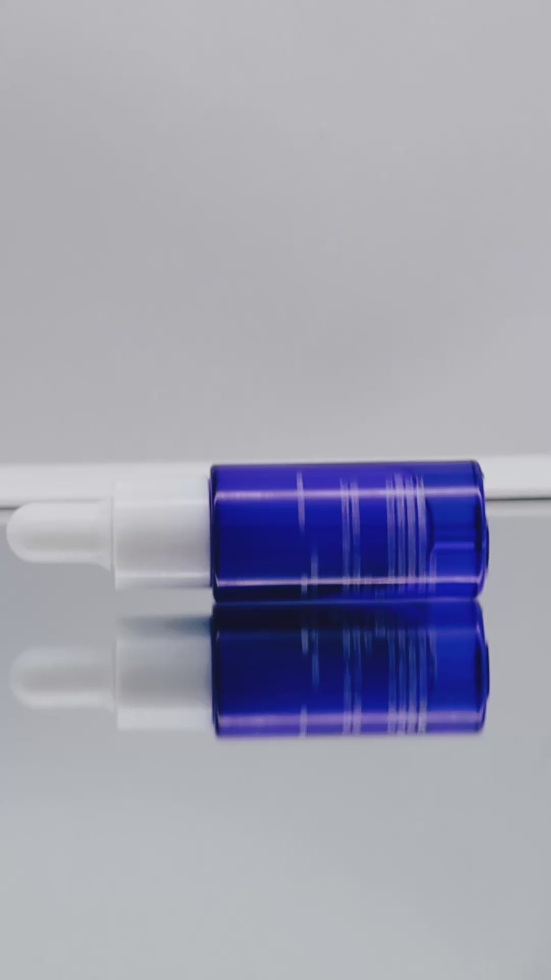 Video: an EXOGLO Serum bottle lying on a reflective surface